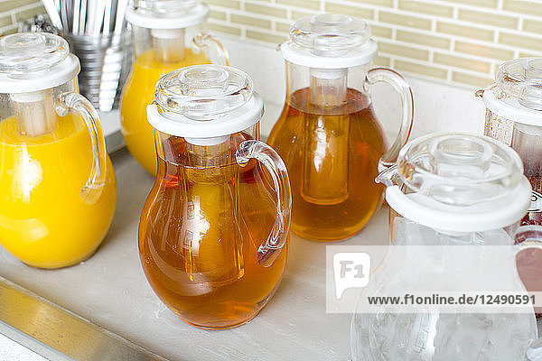 Mit Fruchtsaft gefüllte Gläser werden auf dem Küchentisch verstaut.