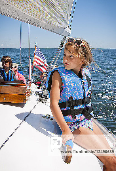 Mädchen sitzt auf einem Segelboot auf dem Meer