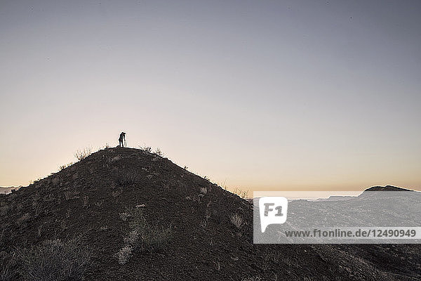 Ein Fotograf mit einem Stativ auf der Spitze eines Hügels im Big Bend National Park  Texas  stehend