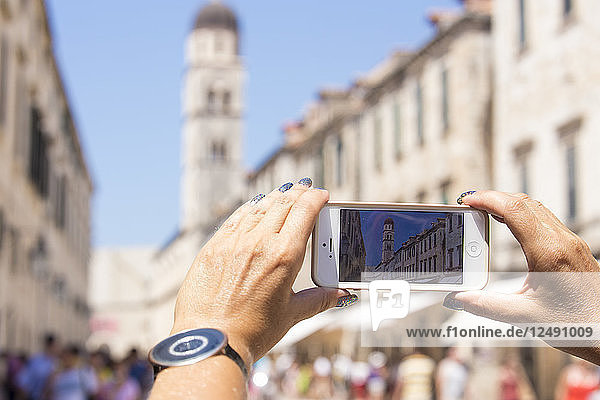 Person Hand  die ein Bild mit einem Mobiltelefon in Dubrovnik  Kroatien