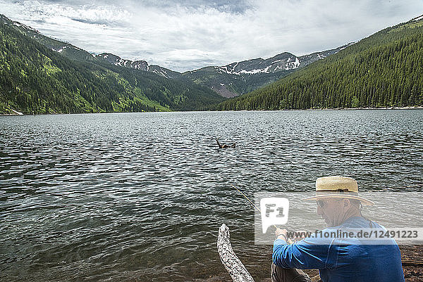 Man Fly Fishing On Lake In The Big Bear Wilderness  Montana  Usa