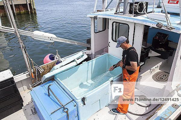 Fischer reinigt sein Boot nach einem Angeltag in Chatham