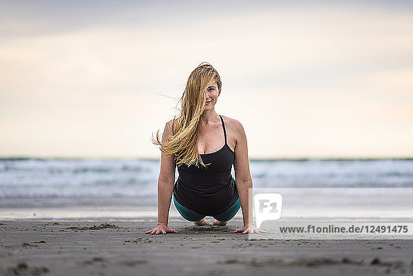 A Woman Doing Yoga At The Beach In Rhode Island On A Windy And Cloudy Day