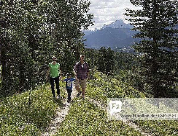 Young family pause at trail fork  in mountains