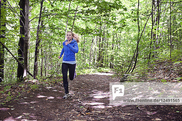 Fit junge Frau Trailrunning auf Pfaden durch den Wald am Mount Sabattus