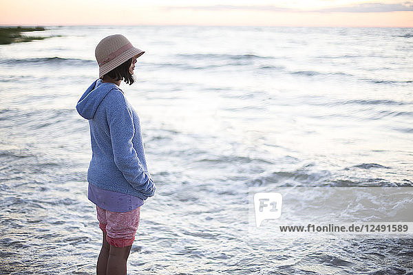 Woman Wearing Summer Hat Standing On Beach
