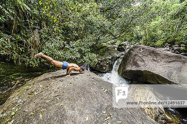 Mann in Pfauenpose am Fluss Pirapetinga im Naturschutzgebiet Serrinha do Alambari  Rio de Janeiro  Brasilien