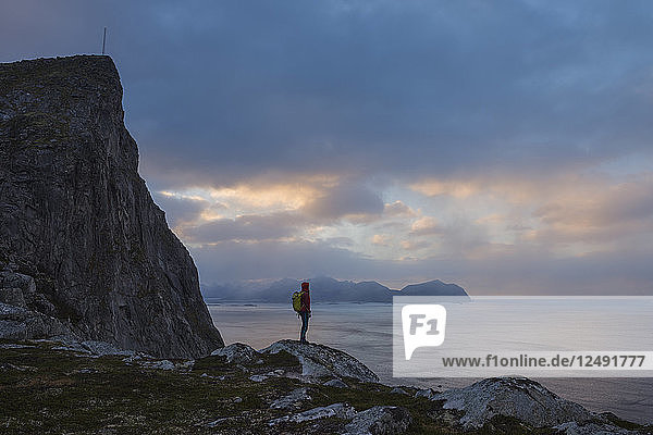 Female hiker stands below M??ntind  Flakstad??y  Lofoten Islands  Norway