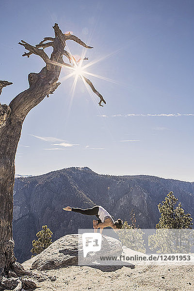 Eine junge Frau praktiziert Yoga auf einer Klippe im Yosemite National Park