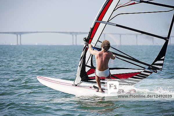 Mann beim Windsurfen an einem sonnigen Sommertag in Rhode Island