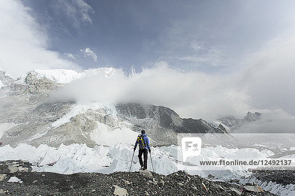A trekker stands over the Khumbu Glacier in Everest Base Camp.