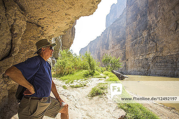 Älterer Mann erkundet den Brown River in einem steilwandigen Wüstencanyon