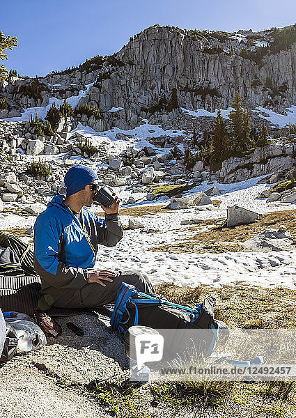 Ein Mann kocht Frühstück und genießt seinen Kaffee beim Camping in der Lone Peak Wilderness in Utahs Wasatch Mountains