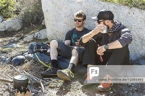 Zwei Wanderer machen eine Pause und genießen einen warmen Kaffee beim Wandern in Richtung des Lone Peak in den Wasatch Mountains in Utah