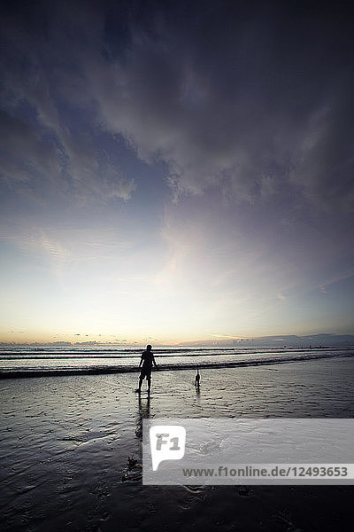 Sonnenaufgang Menschen  die am Strand spazieren gehen.Indonesien Bali Kuta