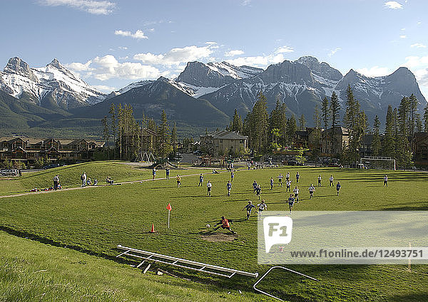 Aerial view of children playing soccer on field in mountains