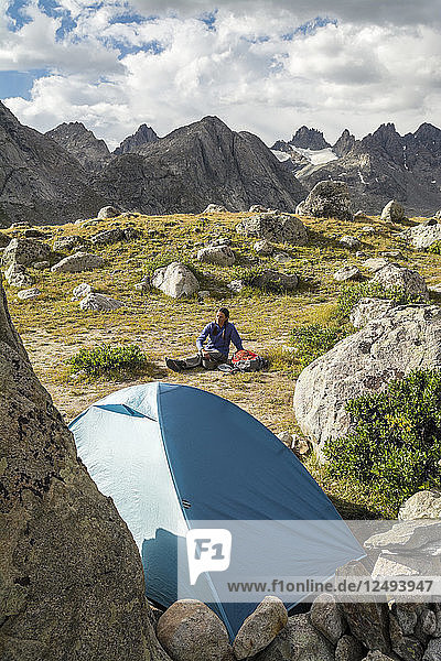 A woman camping in Titcomb Basin  WInd River Range  Pinedale  Wyoming.