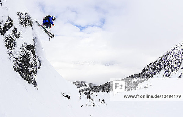 Ein Mann fährt Tiefschnee an einem stürmischen Tag im Skigebiet Whistler Blackcomb in British Columbia