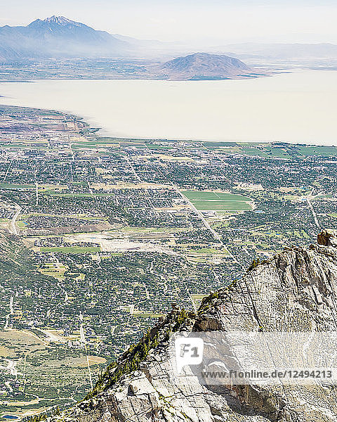 Eine Person klettert die Route auf dem Lone Peak mit Utah Lake und der Stadt Provo in der Ferne zu sehen