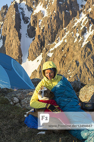 Eine Frau und ihr Hund zelten auf dem Blaine Peak unterhalb des Mount Sneffels