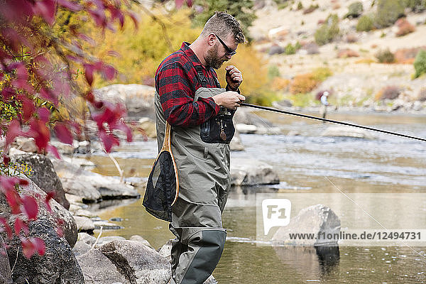 Ein Fliegenfischer beim Vorbereiten seiner Ausrüstung an einem Herbsttag in Breckenridge  Colorado