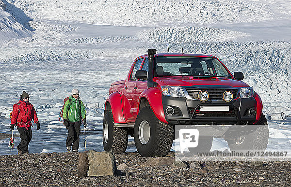 2 Bergsteiger wandern zurück zum maßgeschneiderten SUV / isländischen Superjeep / 4x4 Pick-up-Truck