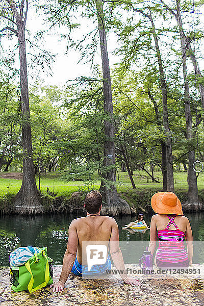 The Blue Hole in Wimberley Texas is a popular destination for tourists and locals on hot summer days. The clear cool water flows through cypress trees and offers a refuge from the Texas heat.