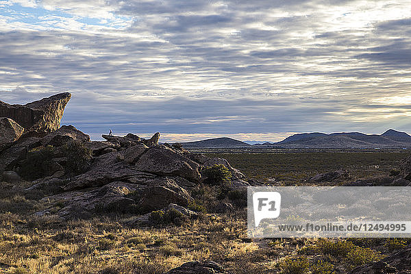 Hiker looks out on sunset of Hueco Tanks State Park  Texas