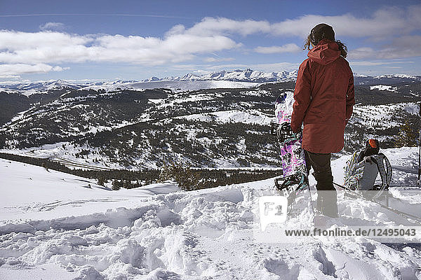 Snowboarder Sandra Hillen Looks Out Over The Rockies After Hiking Up On A Splitboard