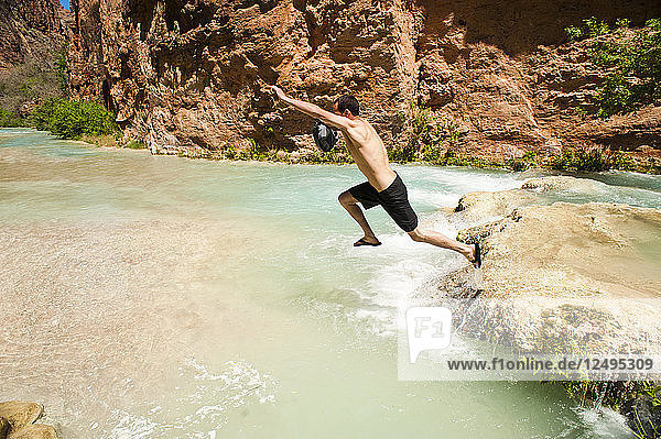 Eine Person springt in ein Schwimmloch im Grand Canyon.