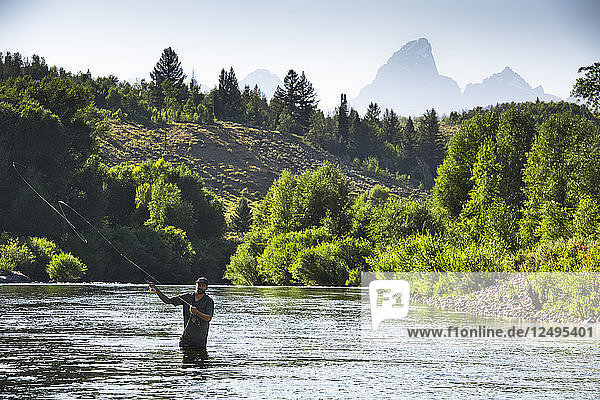 Ein Fliegenfischer im Gros Ventre River mit Grand Teton Mountains im Hintergrund  Jackson Hole  Wyoming