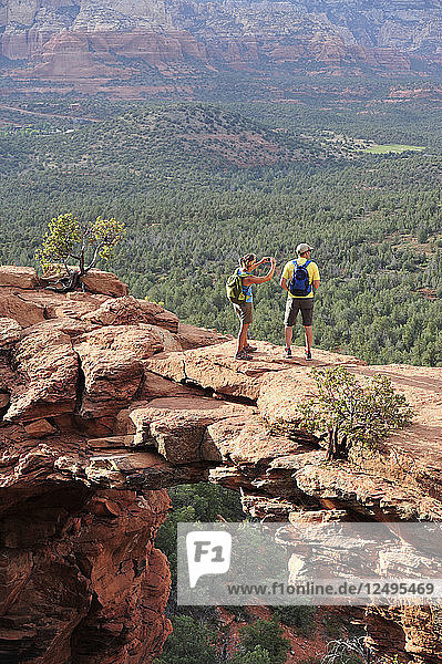 Hikers on the Devil's Bridge in Red Rock-Secret Mountain Wilderness Area outside Sedona  Arizona May 2011. The Devil's Bridge is an easy two-mile hike with spectacular views.