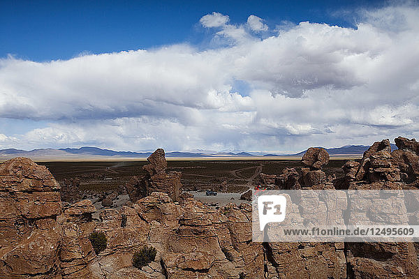 Ein junger Mann spielt auf den Felsen in der Atacama-Wüste. Der Salar de Uyuni ist die größte Salzfläche der Welt und beherbergt eines der größten Lithiumvorkommen der Welt. Die Gemeinden in der Umgebung dieser Region könnten von der Erschließung und dem Abbau stark profitieren oder darunter leiden.