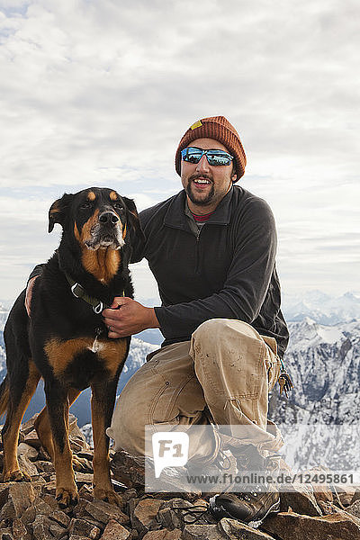 Portrait of a man and his dog on the summit of Frosty Peak  BC  Canada.