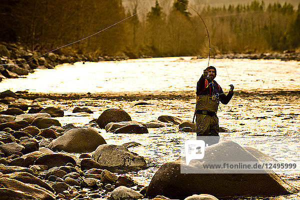 A fly fisherman in action at sunset in Squamish  British Columbia.
