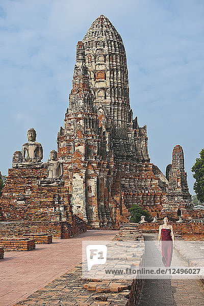 Frau in rotem Kleid im alten Tempel Wat Chaiwatthanaram in Ayutthaya