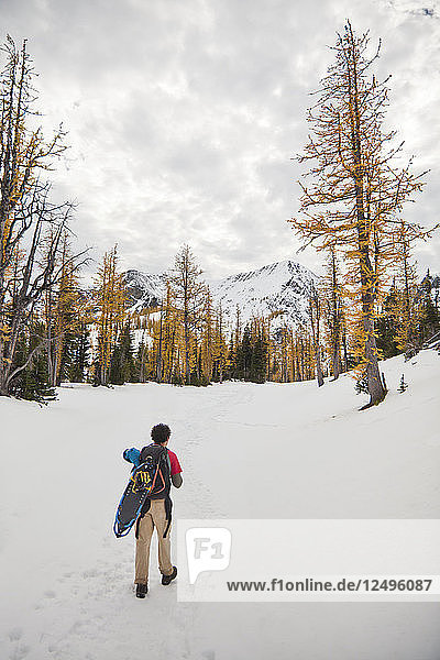 A backpacker hikes through snow toward Frosty Mountain in Manning Provincial Park  BC  Canada.