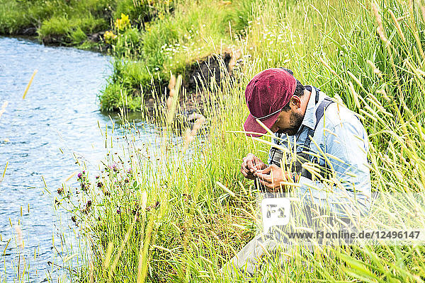 A Fly Fisherman Prepares His Gear While Sitting Next To The Yampa River Colorado