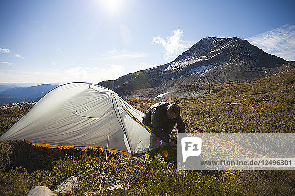 Ein Bergsteiger baut sein Zelt unterhalb des Jim Kelly Peak in Illal Meadows auf