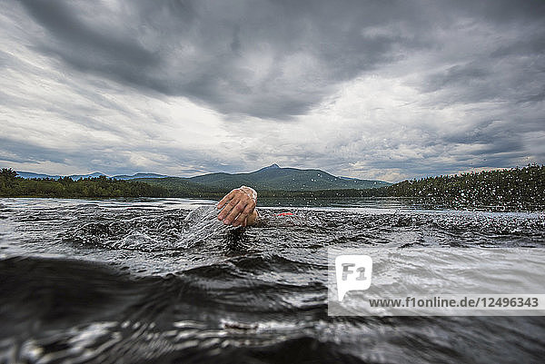 Die Hand eines Schwimmers  der beim Schwimmen im See aus dem Wasser gezogen wird
