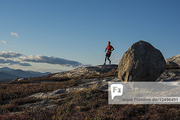 Kevin Tilton läuft in der Nähe eines Gletscherfindlings auf dem Gipfel des Foss Mt. in eaton  NH