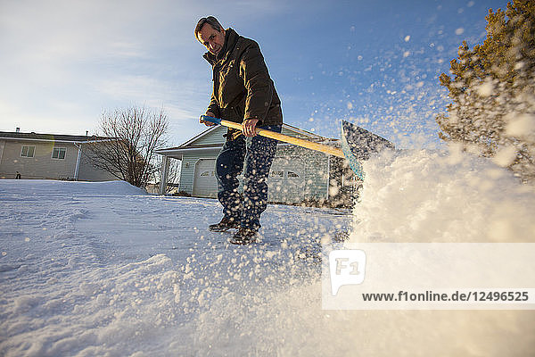 Ein Mann schaufelt Schnee in Nord-Alberta.