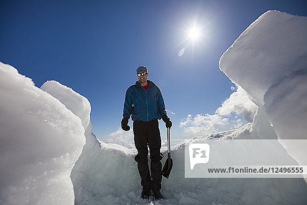 A Man Takes A Break During The Construction Of An Igloo
