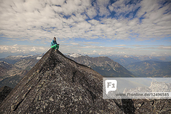 Female Climber Sitting On Top Of Mount Marriott