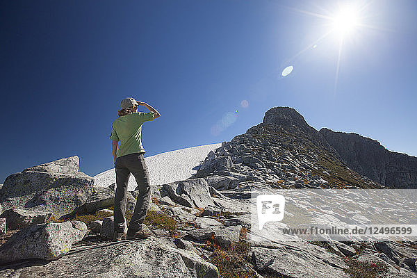 Eine Wanderin blickt auf den vor ihr liegenden Weg  während sie sich dem Gipfel des Gillespie Peak im Pinecone Burke Provincial Park in British Columbia  Kanada  nähert.