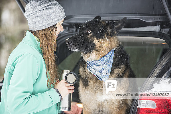Frau und Hund beim Abschluss eines verschneiten Tages in den White Mountains