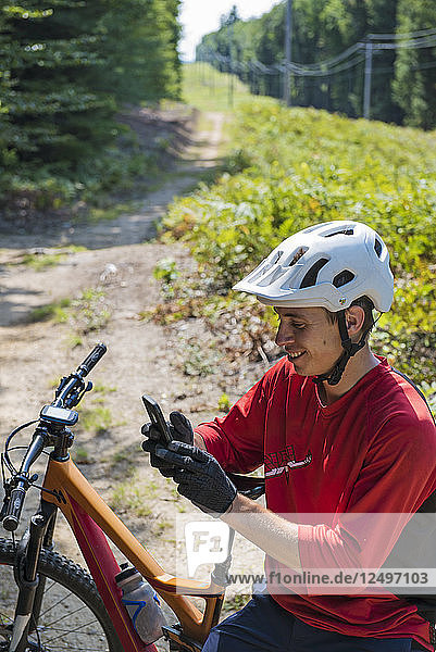 Porträt eines Mountainbikers mit seinem Smartphone