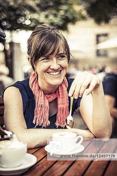 Junge Frau trinkt Kaffee in einem Café in Berlin