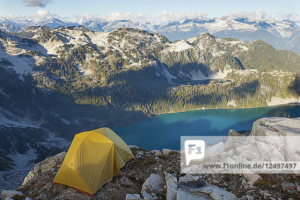 Ein gelbes Zelt hoch oben auf einem Berg über dem Pinecone Lake im Pinecone Burke Provincial Park  British Columbia  Kanada.