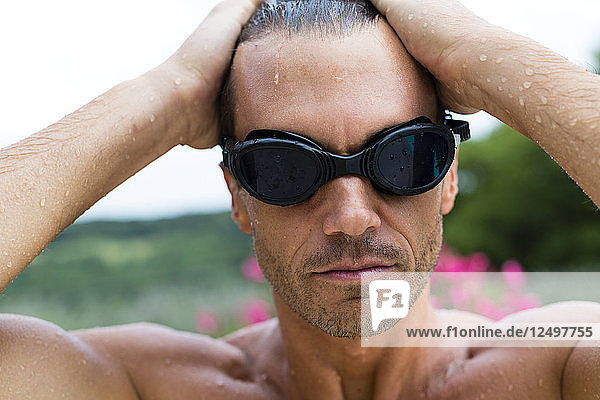 Porträt eines Mannes mit Sonnenbrille und nassem Haar